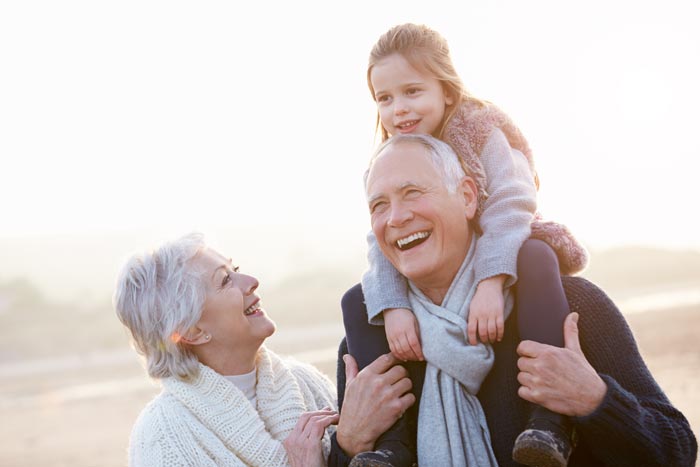 smiling grandparents with granddaughter